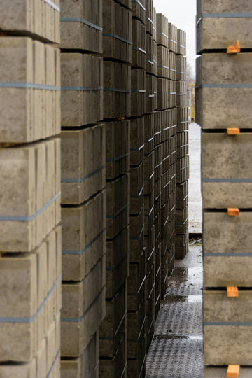 Stacks of grey concrete paving stones outdoors
